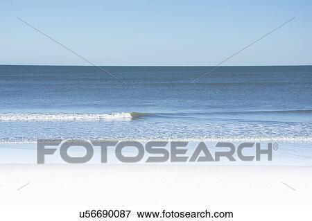Stock Photo - USA, North Carolina, Surf City, Clear sky over beach. Fotosearch