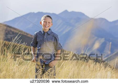 Stock Photograph - USA, Utah, Provo, Boy (6-7) standing in field. Fotosearch
