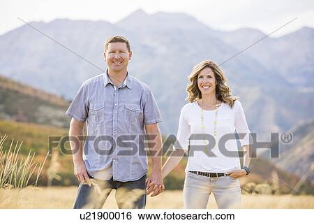 Stock Photograph - USA, Utah, Provo, Smiling couple holding hands. Fotosearch