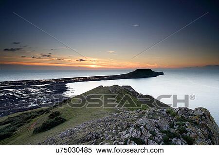 Stock Photography - View of Worm's Head at sunset, Rhossili bay, Gower, Wales. Fotosearch