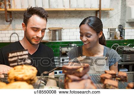 Waiter and waitress preparing food in cafe View Large Photo Image Stock Photo - Waiter and waitress preparing food in cafe. Fotosearch