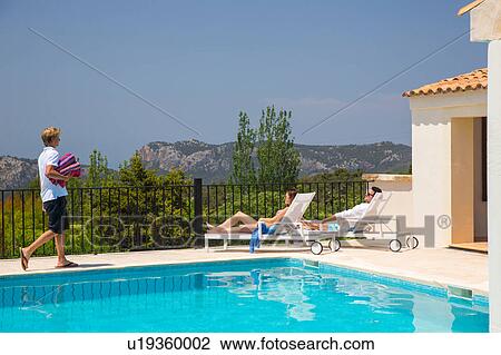 Waiter carrying towels for guest couple by boutique hotel swimming pool, Majorca, Spain View Large Photo Image Stock Image - Waiter carrying towels for guest couple by boutique hotel swimming pool, Majorca, Spain. Fotosearch