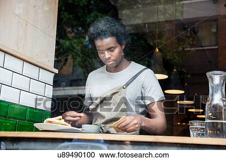 Waiter preparing order at cafe window View Large Photo Image Stock Image - Waiter preparing order at cafe window. Fotosearch