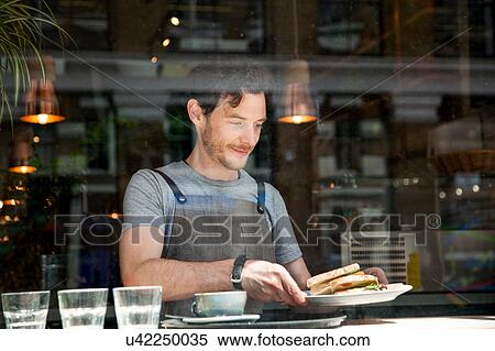 Stock Photography - Waiter preparing order at cafe window. Fotosearch
