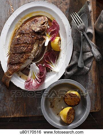 Stock Photograph - Whole grilled snapper on serving tray. Fotosearch