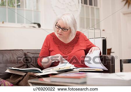 Woman browsing catalogue on couch View Large Photo Image Stock Image - Woman browsing catalogue on couch. Fotosearch