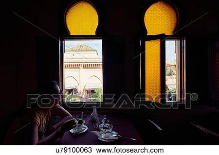 Woman eating dessert and looking through restaurant window, Marrakech, Morocco View Large Photo Image Stock Image - Woman eating dessert and looking through restaurant window, Marrakech, Morocco. Fotosearch