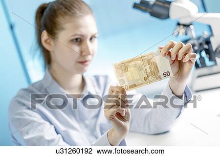 Stock Image - Woman holding banknote. Fotosearch