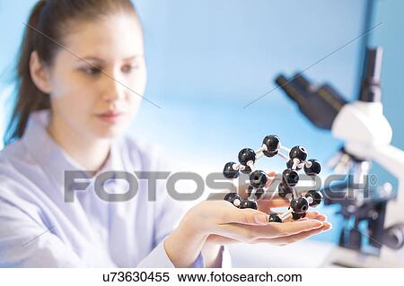 Stock Photography - Woman holding molecular model. Fotosearch