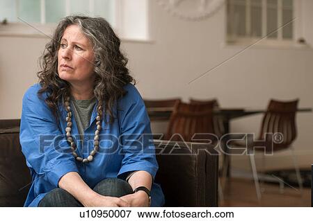 Stock Photo - Woman looking upset on couch. Fotosearch