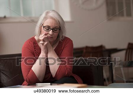 Woman looking upset on couch View Large Photo Image Stock Photo - Woman looking upset on couch. Fotosearch
