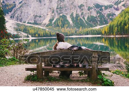 Woman relaxing on park bench, Lago di Braies, Dolomite Alps, Val di Braies, South Tyrol, Italy View Large Photo Image Stock Photography - Woman relaxing on park bench, Lago di Braies, Dolomite Alps, Val di Braies, South Tyrol, Italy. Fotosearch