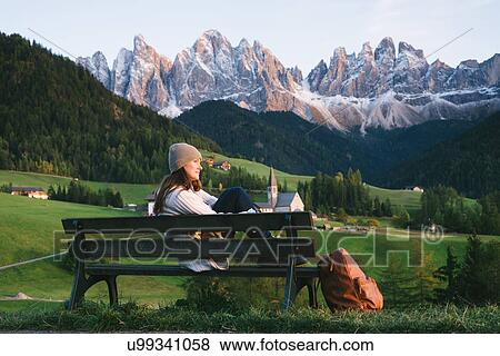 Woman relaxing on park bench, Santa Maddalena, Dolomite Alps, Val di Funes (Funes Valley), South Tyrol, Italy View Large Photo Image Stock Photo - Woman relaxing on park bench, Santa Maddalena, Dolomite Alps, Val di Funes (Funes Valley), South Tyrol, Italy. Fotosearch