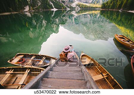 Woman relaxing on pier, Lago di Braies, Dolomite Alps, Val di Braies, South Tyrol, Italy View Large Photo Image Stock Image - Woman relaxing on pier, Lago di Braies, Dolomite Alps, Val di Braies, South Tyrol, Italy. Fotosearch