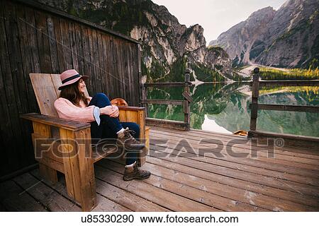 Woman relaxing on wooden chair, Lago di Braies, Dolomite Alps, Val di Braies, South Tyrol, Italy View Large Photo Image Stock Image - Woman relaxing on wooden chair, Lago di Braies, Dolomite Alps, Val di Braies, South Tyrol, Italy. Fotosearch