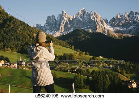 Stock Photo - Woman taking photograph, Santa Maddalena, Dolomite Alps, Val di Funes (Funes Valley), South Tyrol, Italy. Fotosearch