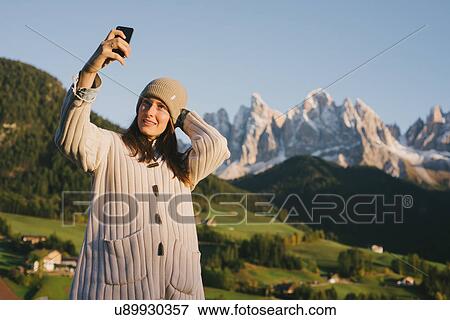 Stock Photo - Woman taking selfie, Santa Maddalena, Dolomite Alps, Val di Funes (Funes Valley), South Tyrol, Italy. Fotosearch