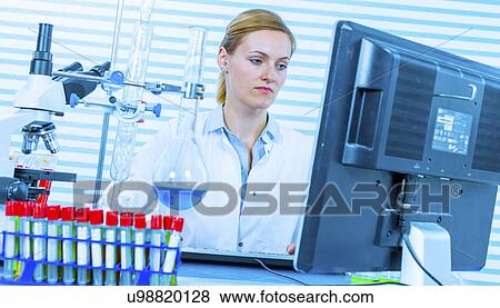 Stock Photo - Woman using computer in chemical laboratory. Fotosearch