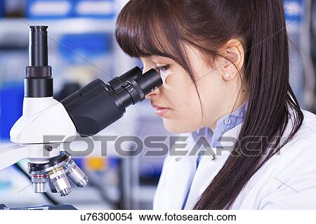 Picture - Woman using microscope. Fotosearch