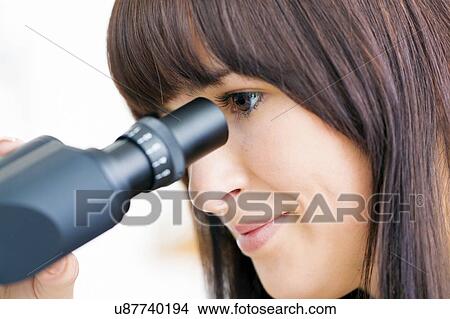 Picture - Woman using microscope. Fotosearch