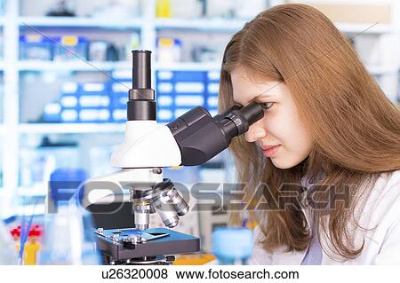 Stock Photo - Woman using microscope. Fotosearch