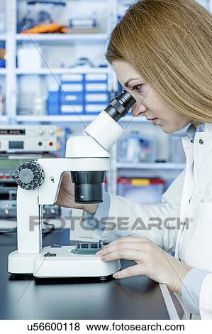 Stock Photo - Woman using microscope. Fotosearch