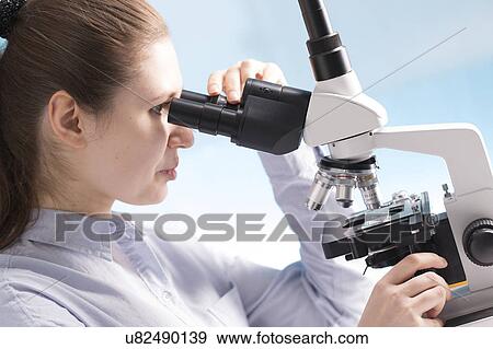 Stock Photo - Woman using microscope. Fotosearch