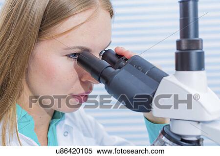 Stock Photography - Woman using microscope. Fotosearch