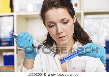 Stock Photo - Woman working in microbiology laboratory. Fotosearch
