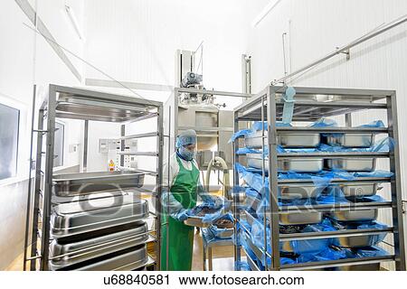 Stock Image - Worker making curry paste in Asian food factory. Fotosearch