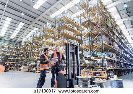 Stock Photo - Workers in cable store warehouse at cable storage facility. Fotosearch