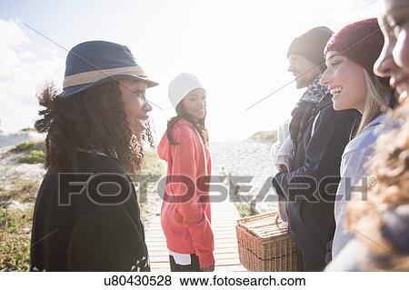 Young adult friends chatting on beach boardwalk, Western Cape, South Africa View Large Photo Image Stock Photo - Young adult friends chatting on beach boardwalk, Western Cape, South Africa. Fotosearch
