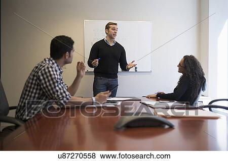 Stock Photo - Young business people having meeting in board room. Fotosearch