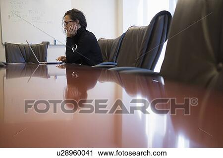 Young business woman sitting in conference room with laptop View Large Photo Image Stock Image - Young business woman sitting in conference room with laptop. Fotosearch