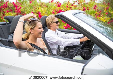 Young couple driving convertible past blossoms, Majorca, Spain View Large Photo Image Stock Photo - Young couple driving convertible past blossoms, Majorca, Spain. Fotosearch