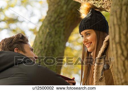 Young couple in forest, face to face, smiling View Large Photo Image Stock Image - Young couple in forest, face to face, smiling. Fotosearch