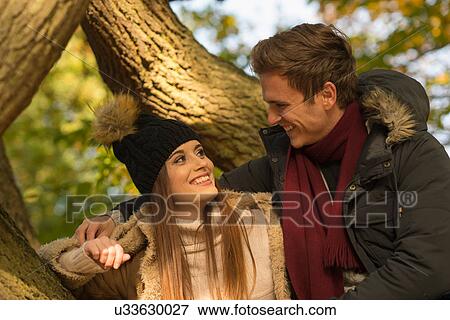 Young couple in forest, face to face, smiling View Large Photo Image Stock Photo - Young couple in forest, face to face, smiling. Fotosearch