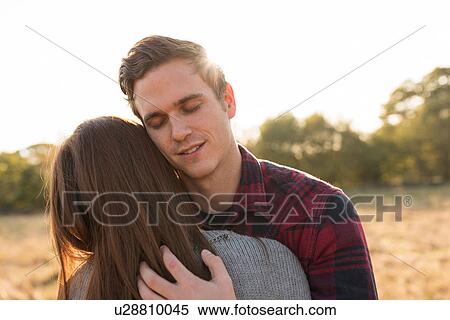 Young couple in rural setting, embracing View Large Photo Image Stock Photography - Young couple in rural setting, embracing. Fotosearch
