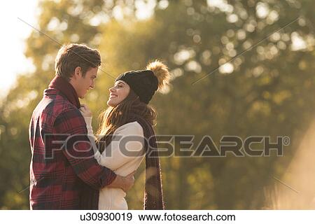 Young couple in rural setting, face to face, smiling View Large Photo Image Stock Photo - Young couple in rural setting, face to face, smiling. Fotosearch