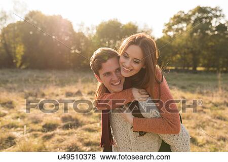 Young couple in rural setting, young man giving young woman piggyback View Large Photo Image Stock Photo - Young couple in rural setting, young man giving young woman piggyback. Fotosearch