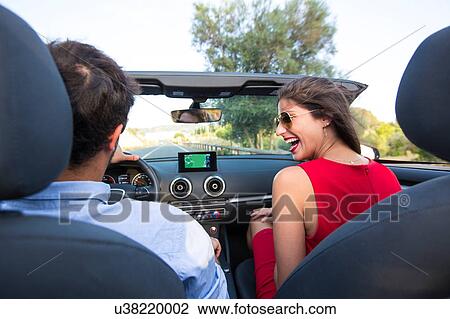 Young couple laughing whilst driving on rural road in convertible, Majorca, Spain View Large Photo Image Stock Image - Young couple laughing whilst driving on rural road in convertible, Majorca, Spain. Fotosearch