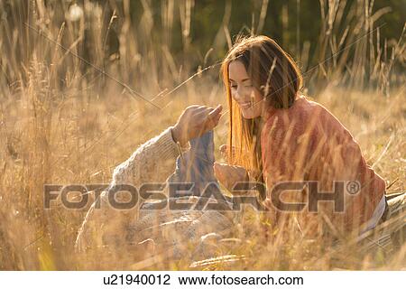 Stock Image - Young couple lying in field. Fotosearch