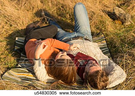 Young couple lying in field View Large Photo Image Stock Photography - Young couple lying in field. Fotosearch
