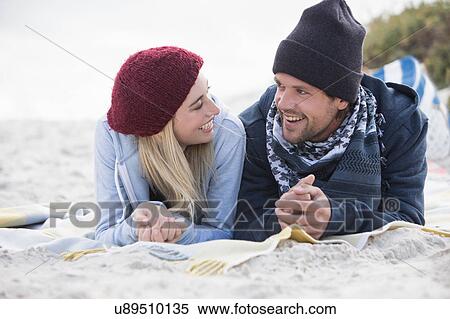 Young couple lying on picnic blanket chatting at beach, Western Cape, South Africa View Large Photo Image Stock Photography - Young couple lying on picnic blanket chatting at beach, Western Cape, South Africa. Fotosearch