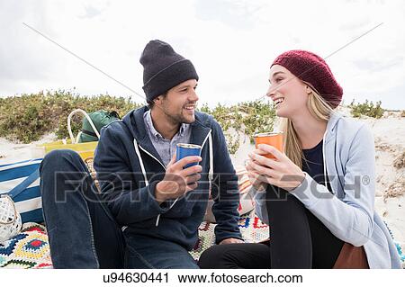 Stock Image - Young couple picnicking on beach, Western Cape, South Africa. Fotosearch