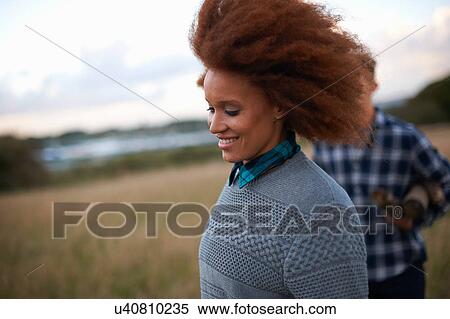 Stock Photography - Young couple running in coastal field. Fotosearch
