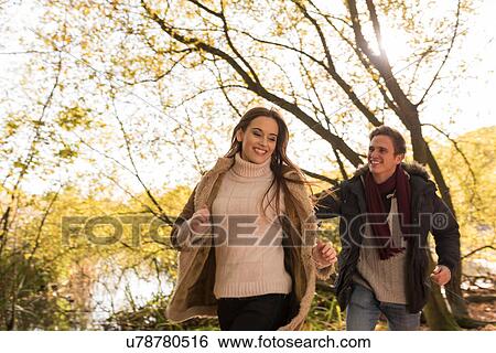 Young couple running in forest, laughing View Large Photo Image Stock Photograph - Young couple running in forest, laughing. Fotosearch