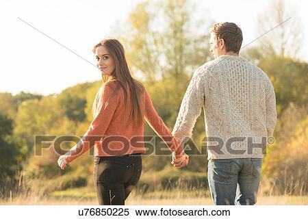 Young couple walking in rural setting View Large Photo Image Stock Photography - Young couple walking in rural setting. Fotosearch