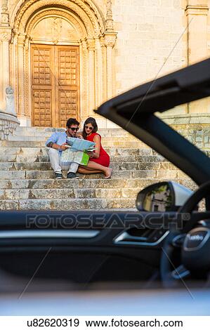 Young couple with convertible sitting on church stairway looking at map, Calvia, Majorca, Spain View Large Photo Image Stock Photo - Young couple with convertible sitting on church stairway looking at map, Calvia, Majorca, Spain. Fotosearch