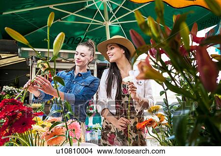 Picture - Young female tourist selecting flowers at market stall, Split, Dalmatia, Croatia. Fotosearch